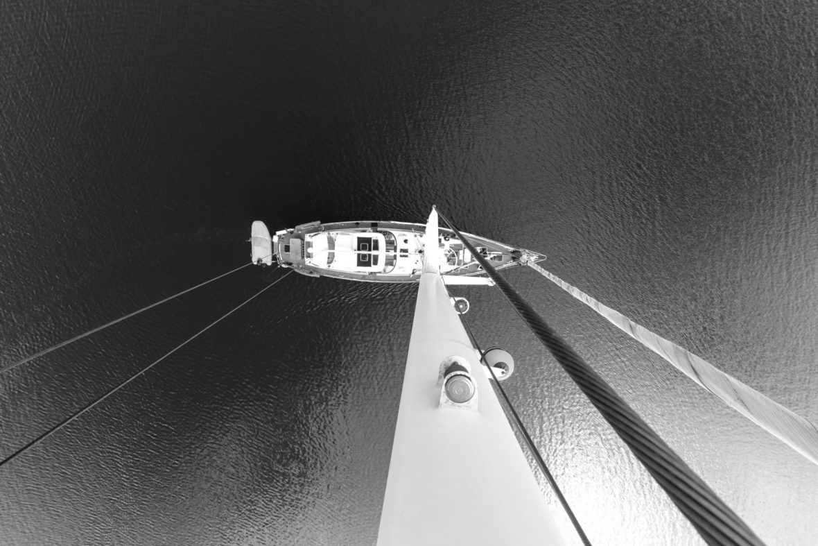 Sort/hvitt bilde av Seilbåt tatt bilde av fra masta og nedover, på åpent hav