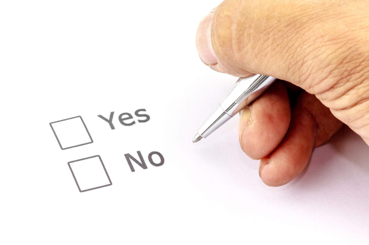Person holder penn over et papir med to bokser hvor det står "Yes" og "No"