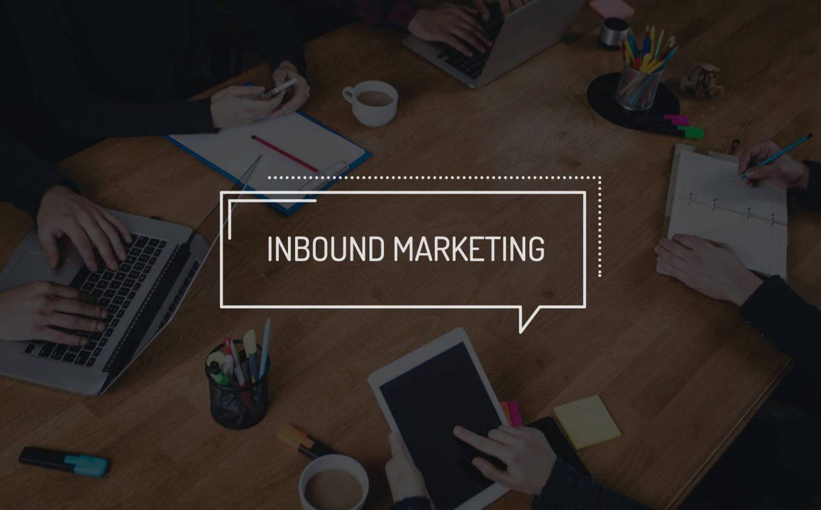 Fire personer har workshop rundt et bord. Ordet Inbound Marketing er lagt over bildet