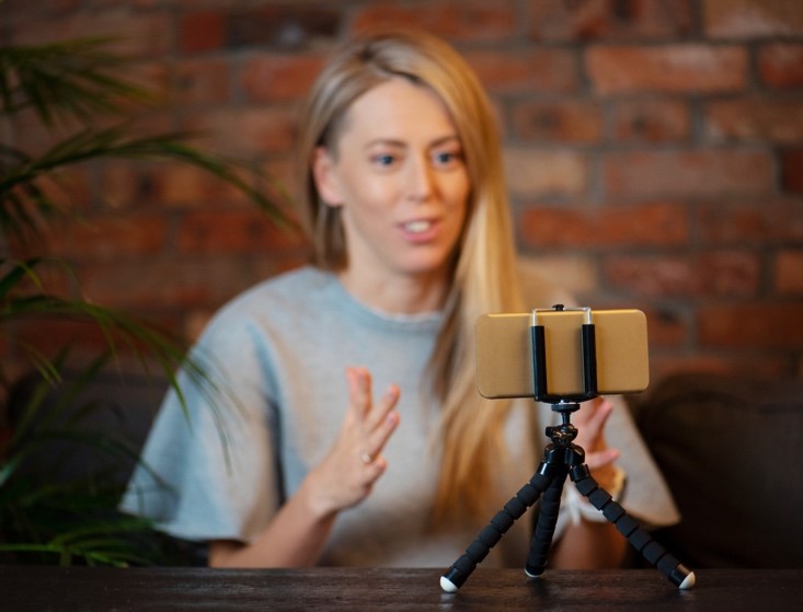 Foto av kvinne som filmer video av seg selv med en smarttelefon