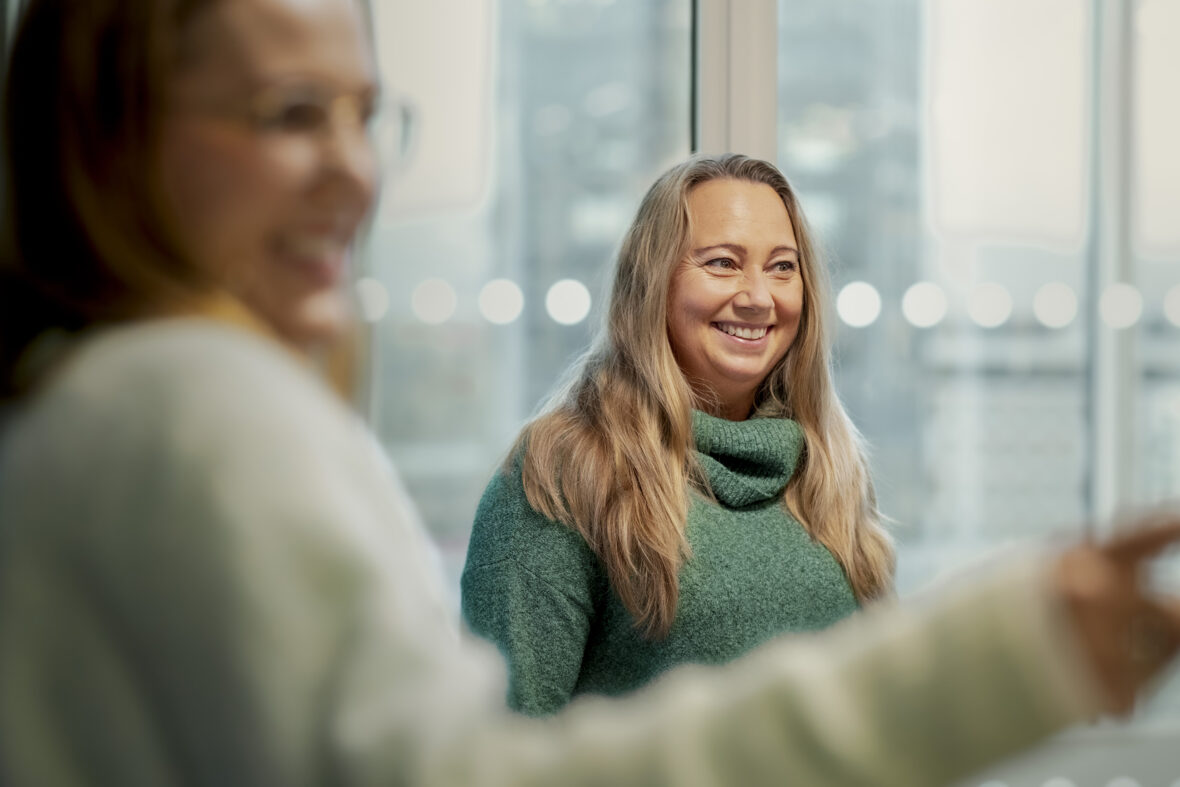 Hanne Tysnes Holm smiler, mens Lena Øverby ler og peker.