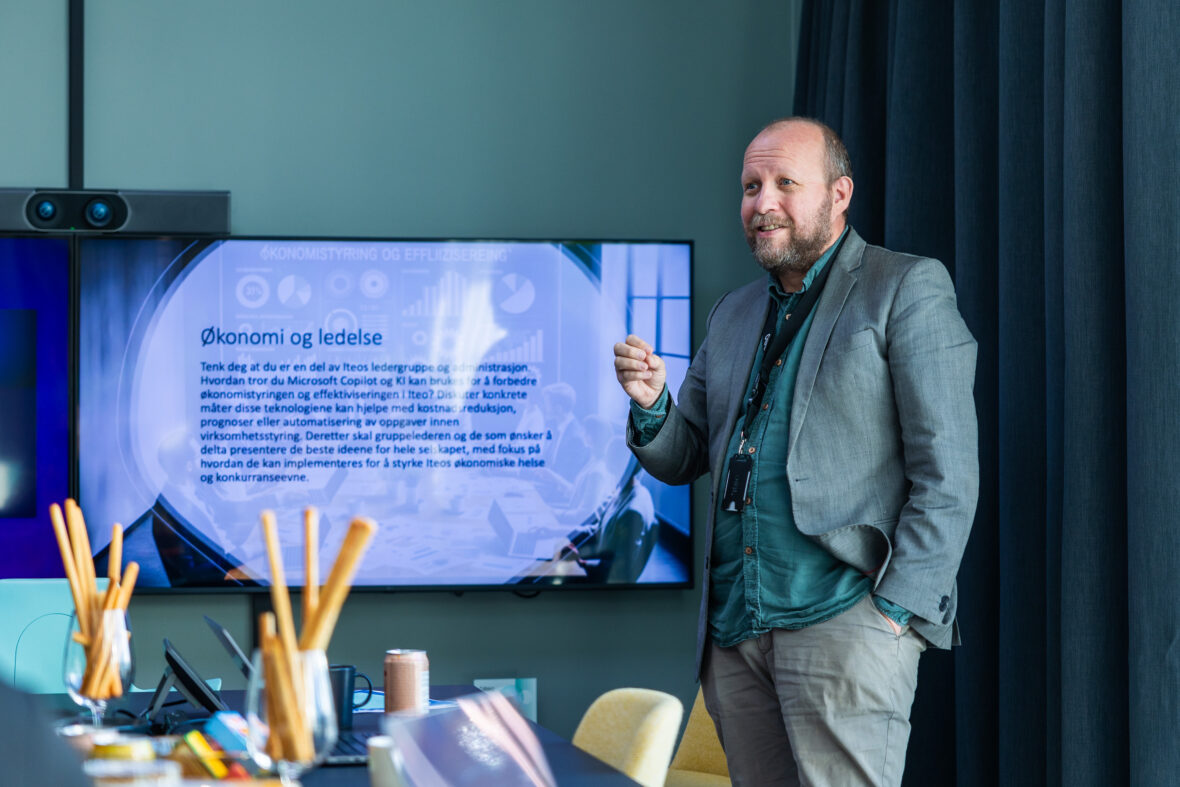 Ansatt holder presentasjon foran skjerm på et kontor